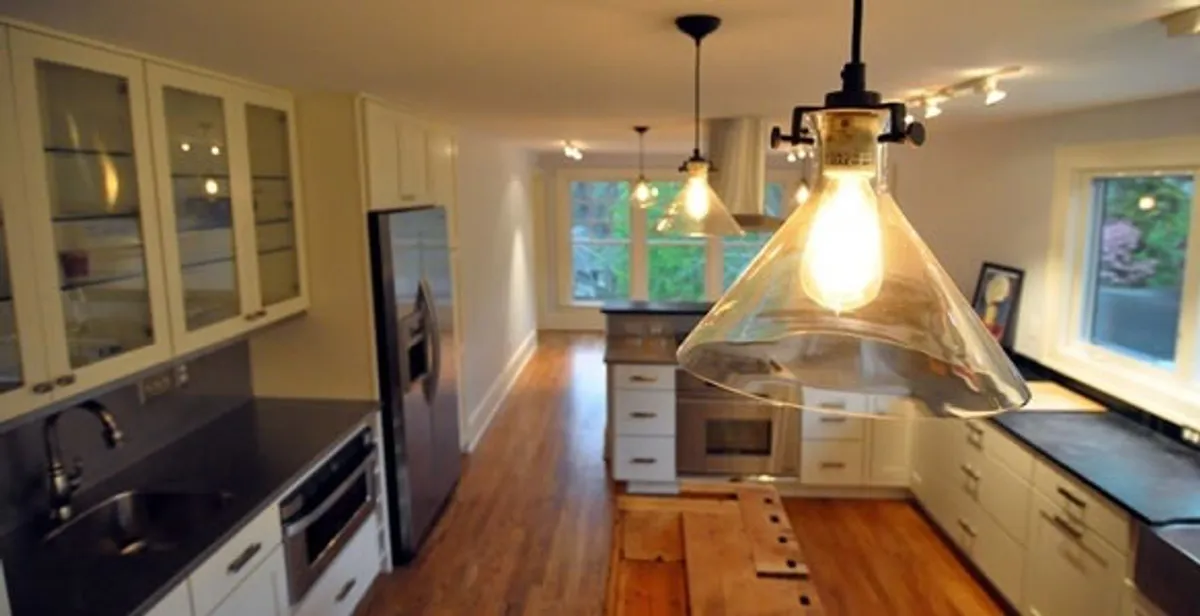 Residential electrician installing modern indoor light fixture in a home in Long Beach, CA
